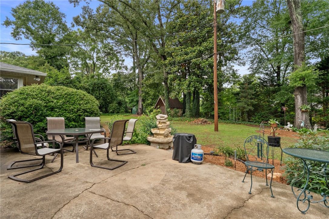 1105 Greenacres Anderson, SC 29621 - Photo 40 of 46 A spacious backyard patio with a tiered water fountain provides a serene outdoor retreat.