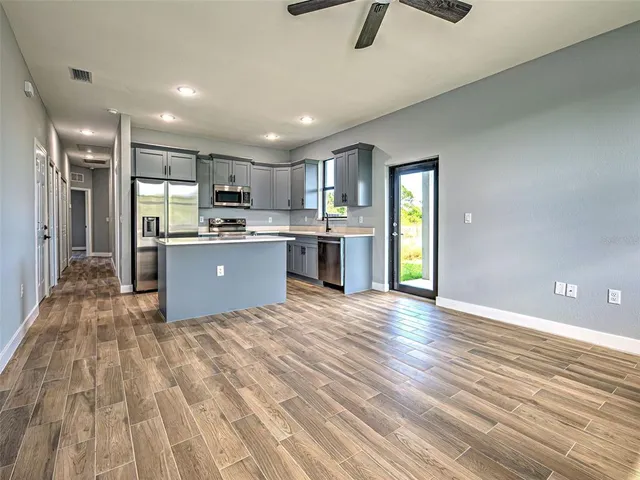 a large kitchen with kitchen island a sink stainless steel appliances and cabinets