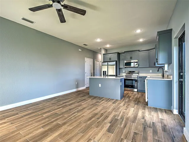 a kitchen with stainless steel appliances kitchen island wooden cabinets and granite counter tops