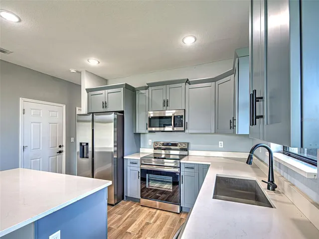 a kitchen with granite countertop a refrigerator and a sink
