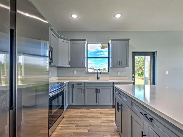 a kitchen with stainless steel appliances granite countertop a sink stove and refrigerator