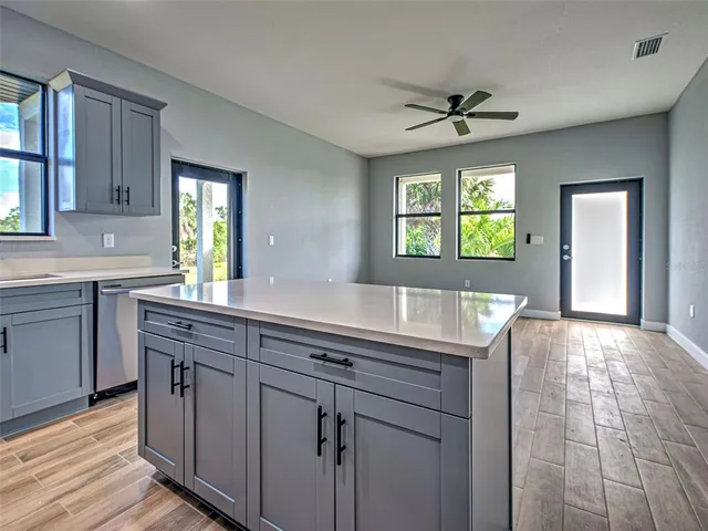 a kitchen with kitchen island granite countertop a sink cabinets and window