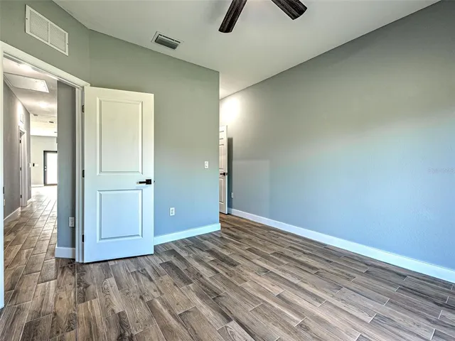 a view of a livingroom with wooden floor and kitchen space