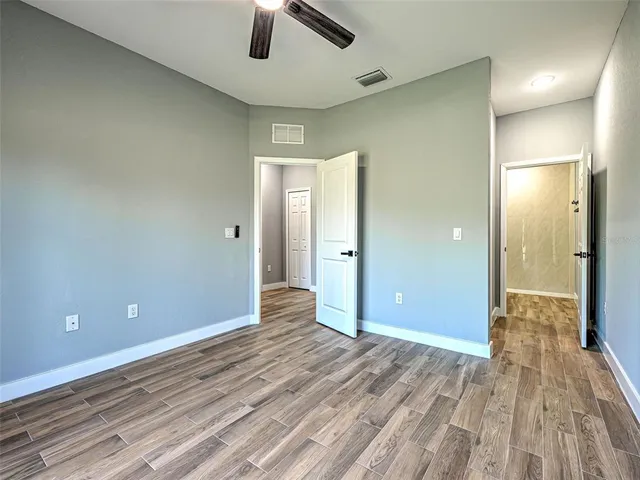 an empty room with closet and a ceiling fan
