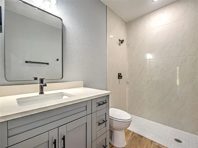 a bathroom with a sink a toilet and shower