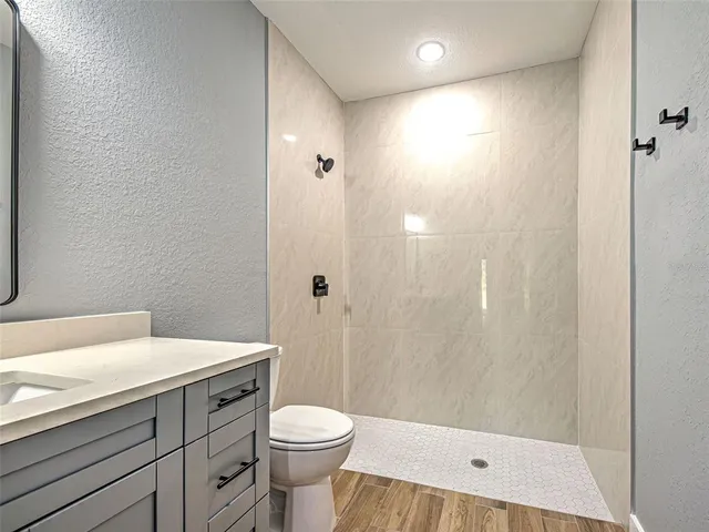 a bathroom with a sink a toilet and shower