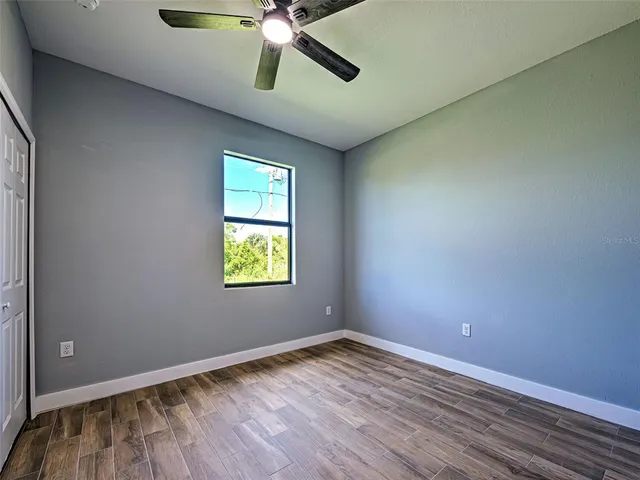 an empty room with a window and wooden floor