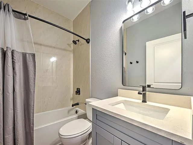 a bathroom with a sink a toilet a mirror and shower