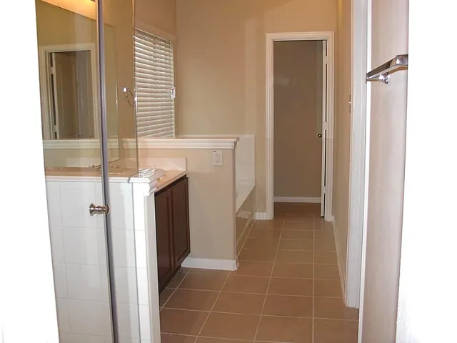 a view of a hallway with closet and a window