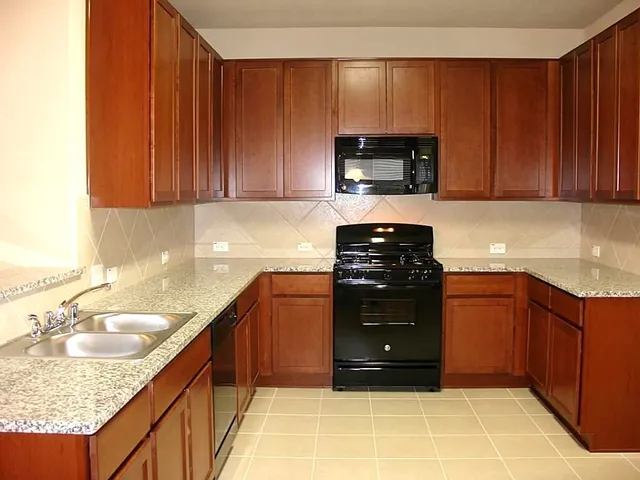 a kitchen with a sink a stove and cabinets