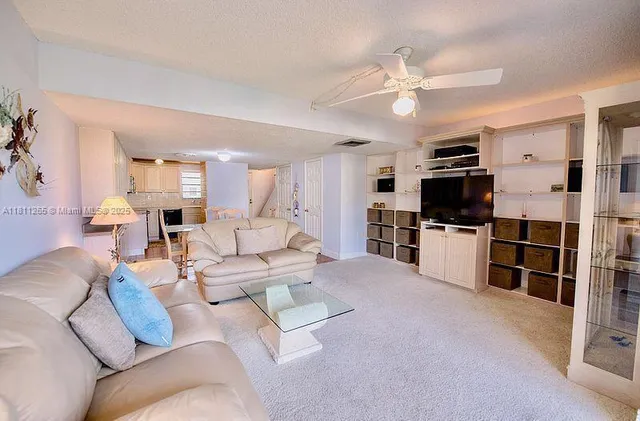 a living room with furniture and kitchen view