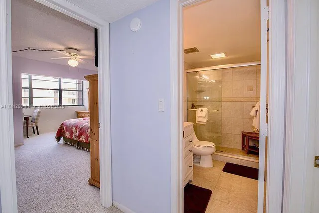 a en suite bathroom with a granite countertop toilet and a view of bathroom