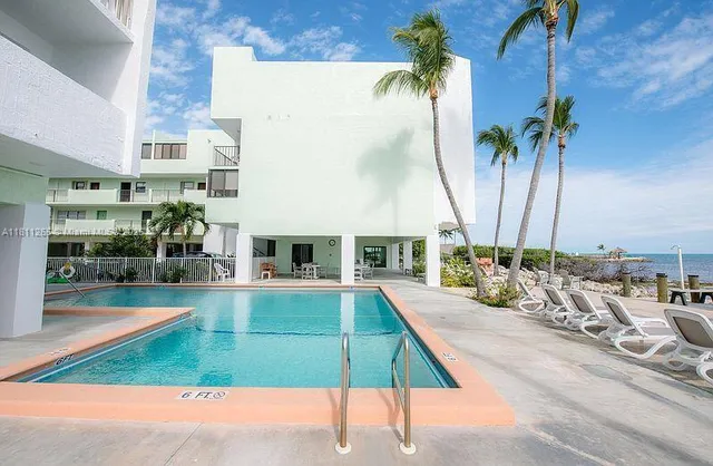 a view of a house with pool lawn chairs and couches