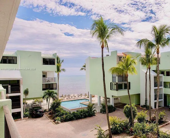 a front view of multi story residential apartment building with yard and outdoor seating