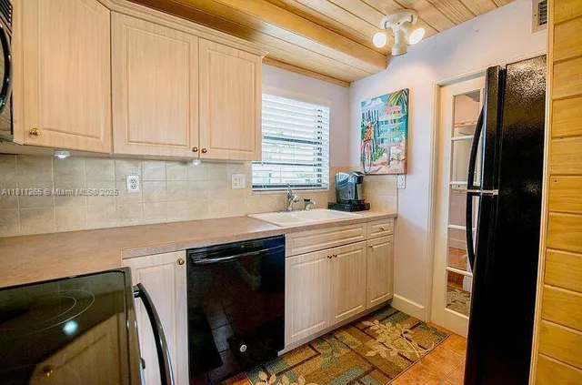a kitchen with stainless steel appliances granite countertop a refrigerator sink and white cabinets