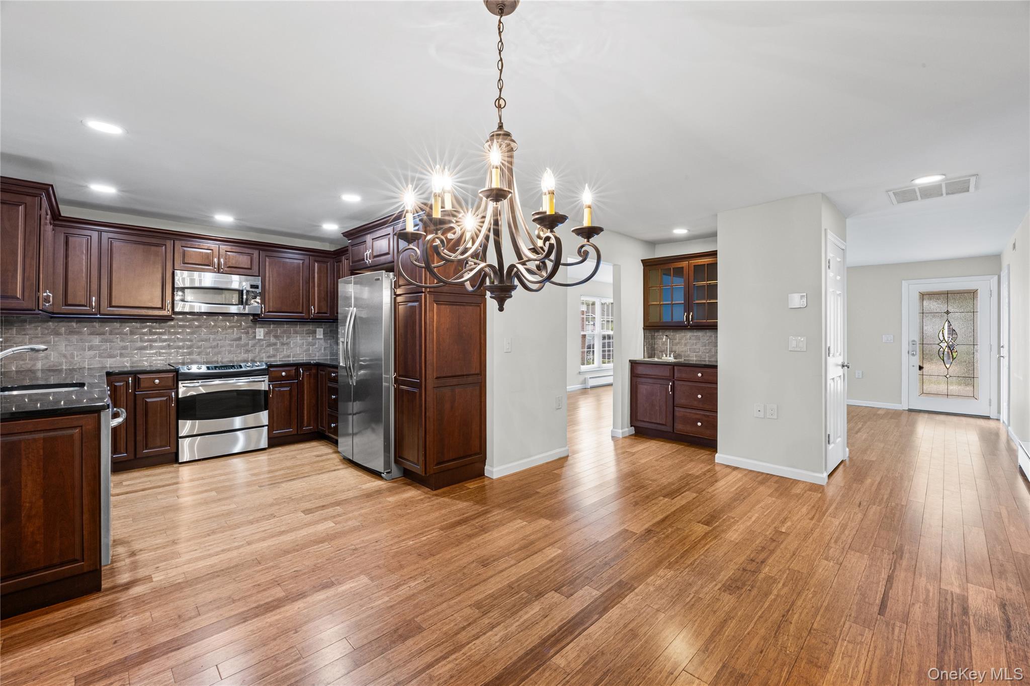 220 Belfast Lane Ridge, NY 11961 - Photo 19 of 44 a kitchen with stainless steel appliances granite countertop wooden floors and granite counter tops