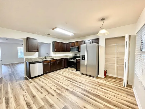 a kitchen with stainless steel appliances kitchen island granite countertop a refrigerator and a stove top oven