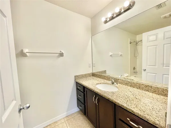 a bathroom with a granite countertop sink and a mirror