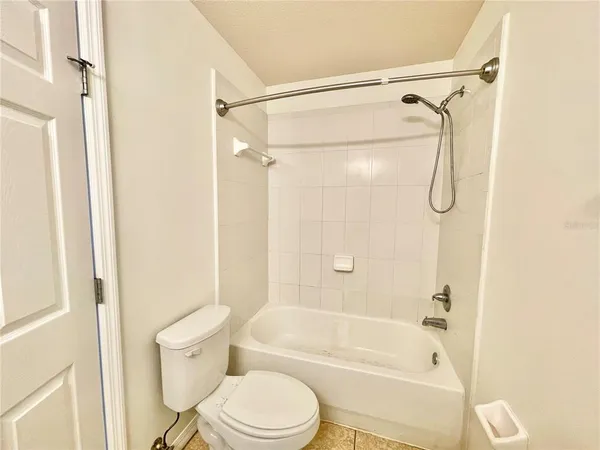 a bathroom with a bathtub shower and a toilet