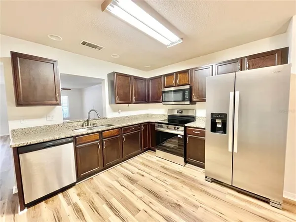 a kitchen with granite countertop stainless steel appliances and wooden cabinets