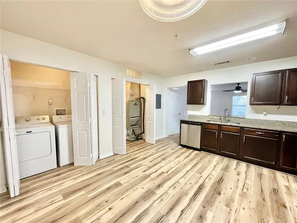a kitchen with stainless steel appliances kitchen island granite countertop a refrigerator and a sink