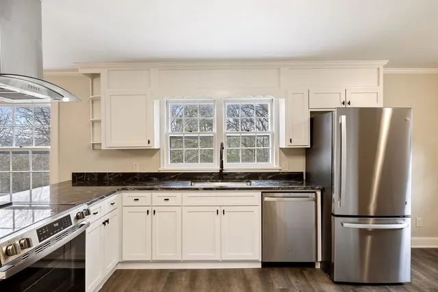 a large kitchen with cabinets and wooden floor