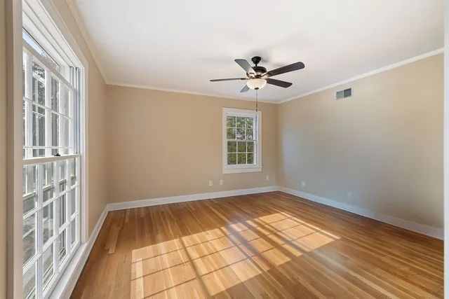 a view of empty room with wooden floor and windows