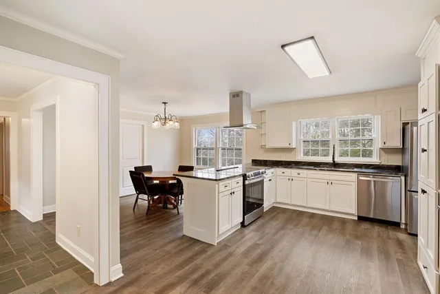 a kitchen with granite countertop a refrigerator sink and cabinets