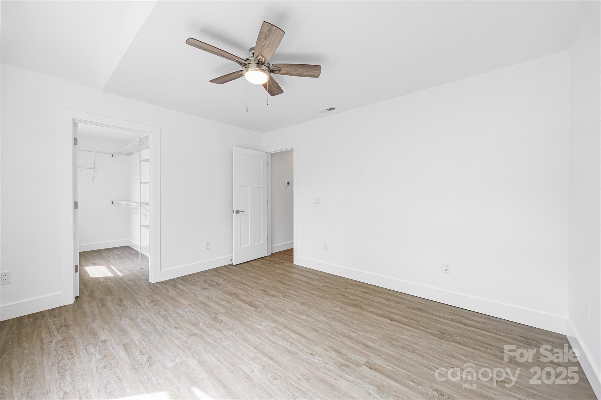 2027 Marquesas Avenue Tega Cay, SC 29708 - Photo 22 of 46 an empty room with wooden floor fan and windows