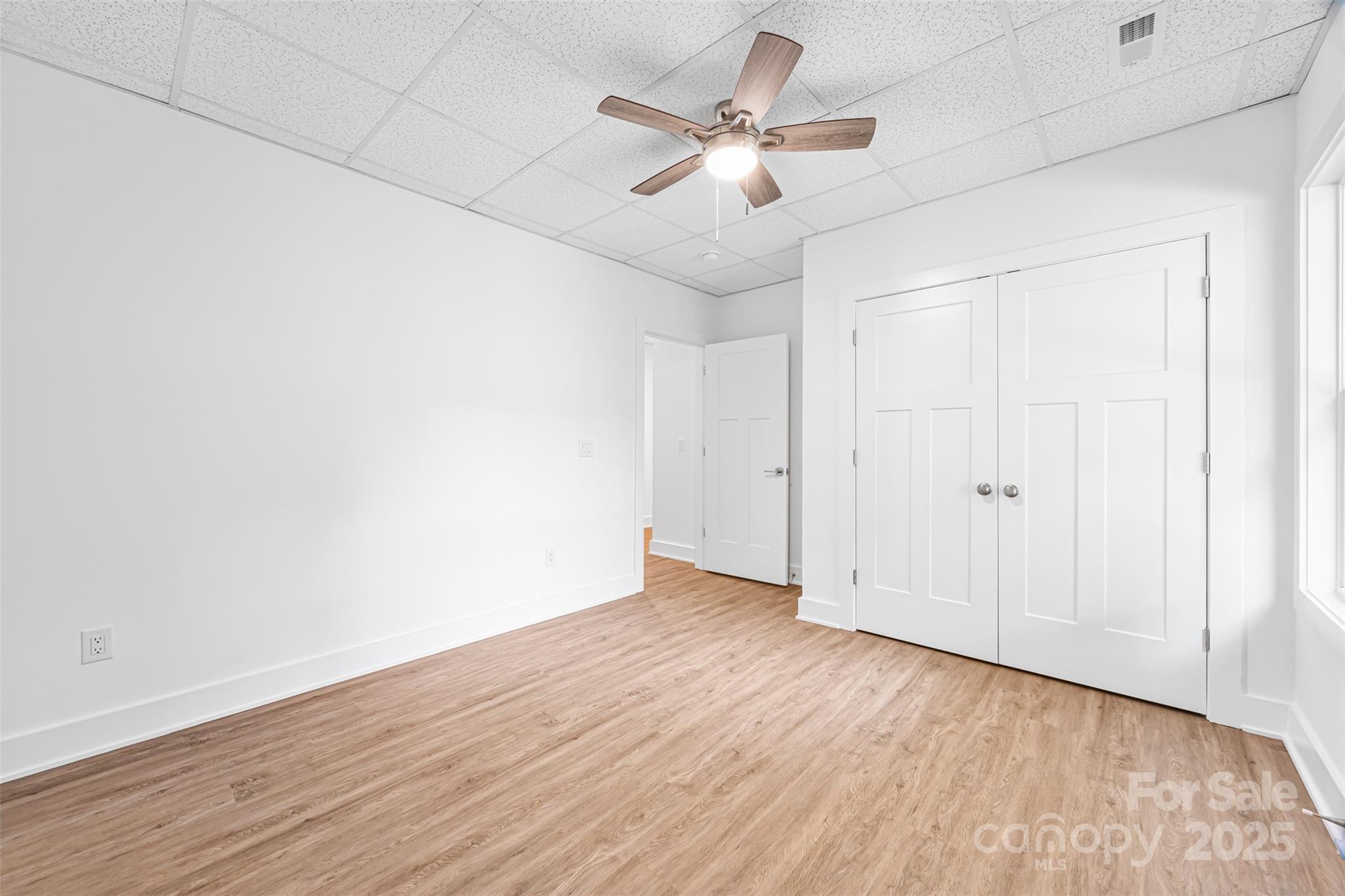 2027 Marquesas Avenue Tega Cay, SC 29708 - Photo 35 of 46 an empty room with wooden floor and ceiling fan