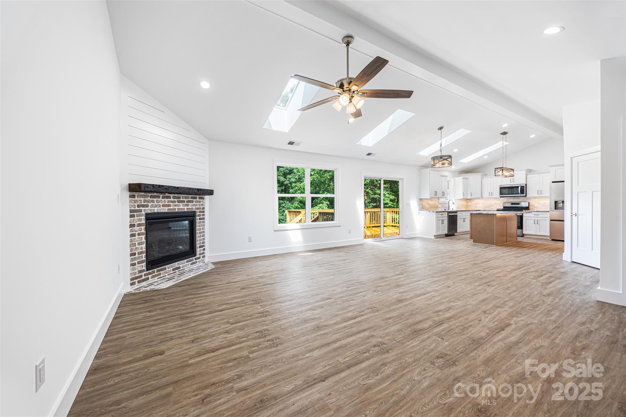 2027 Marquesas Avenue Tega Cay, SC 29708 - Photo 5 of 46 an empty room with wooden floor fireplace and windows