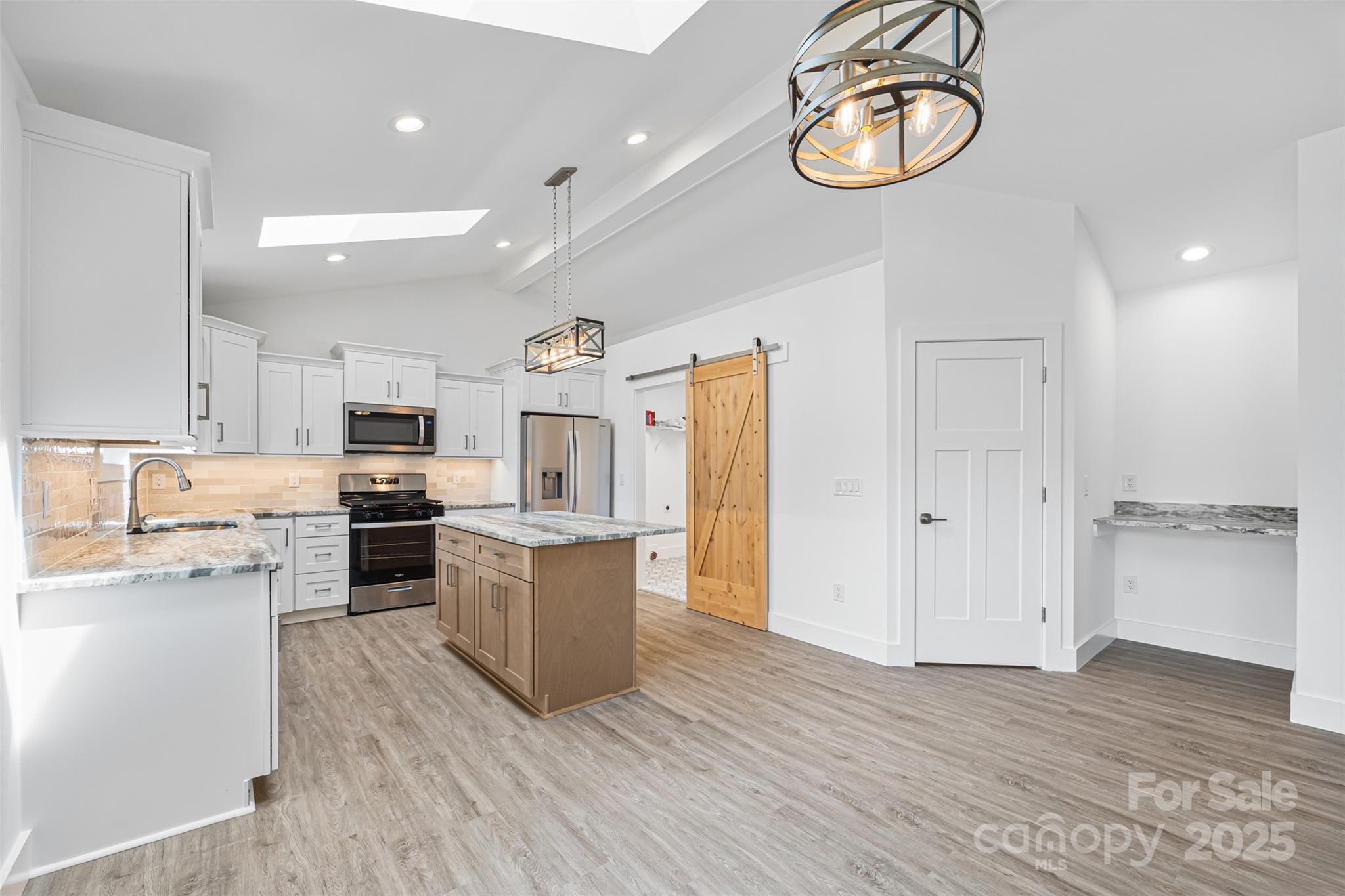 2027 Marquesas Avenue Tega Cay, SC 29708 - Photo 7 of 46 a open kitchen with cabinets wooden floor and stainless steel appliances