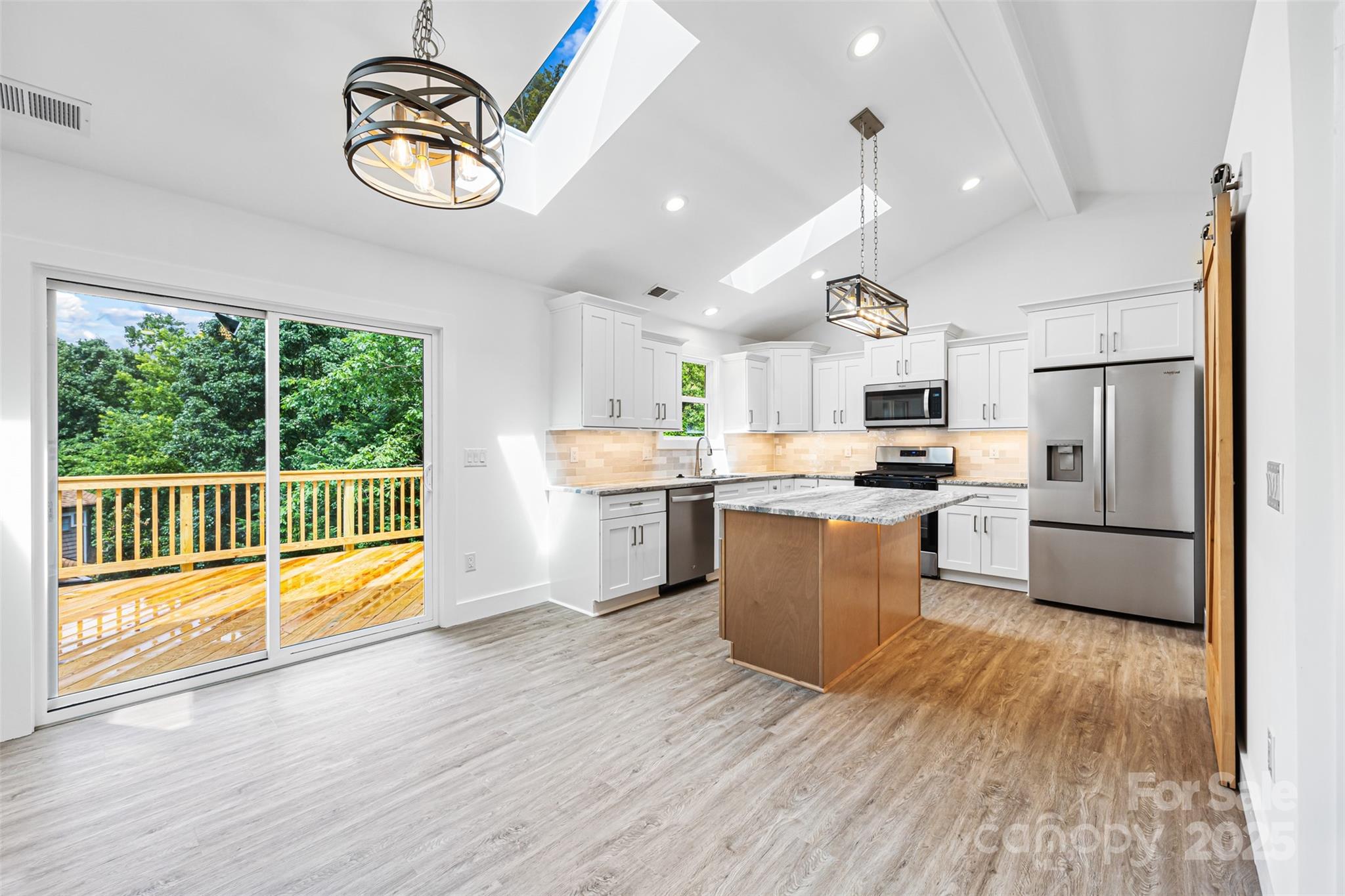 2027 Marquesas Avenue Tega Cay, SC 29708 - Photo 8 of 46 a kitchen with kitchen island wooden floors and center island