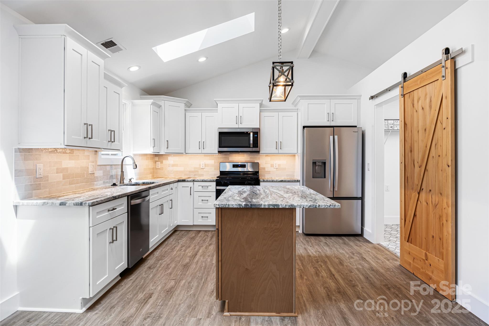 2027 Marquesas Avenue Tega Cay, SC 29708 - Photo 10 of 46 a kitchen with stainless steel appliances granite countertop a refrigerator a stove top oven a sink and dishwasher with wooden floor