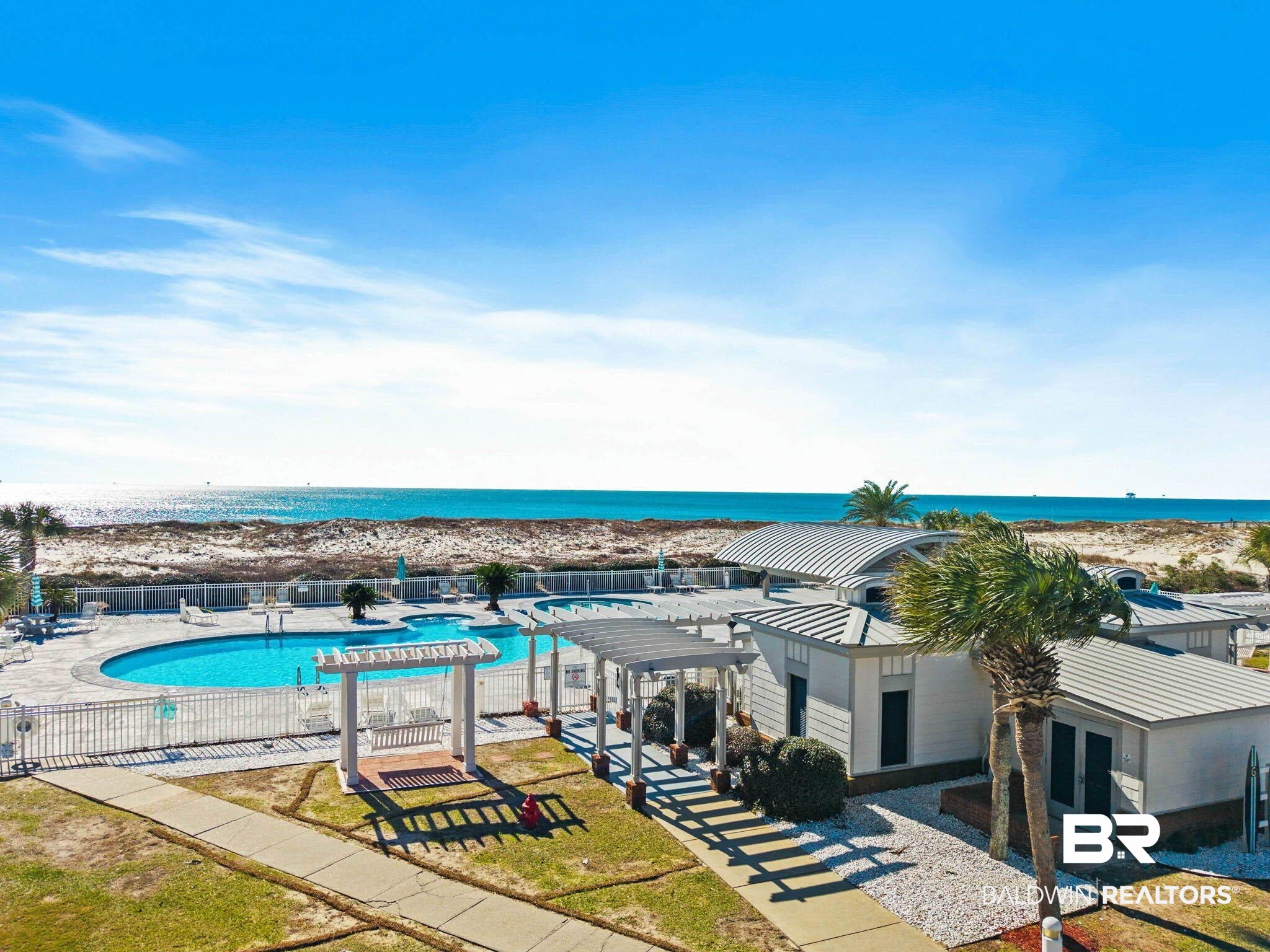 400 Plantation Road, Unit 4501 Gulf Shores, AL 36542 - Photo 21 of 30 Oceanfront property featuring a swimming pool, paved walkways, white buildings with metal roofs, and palm trees