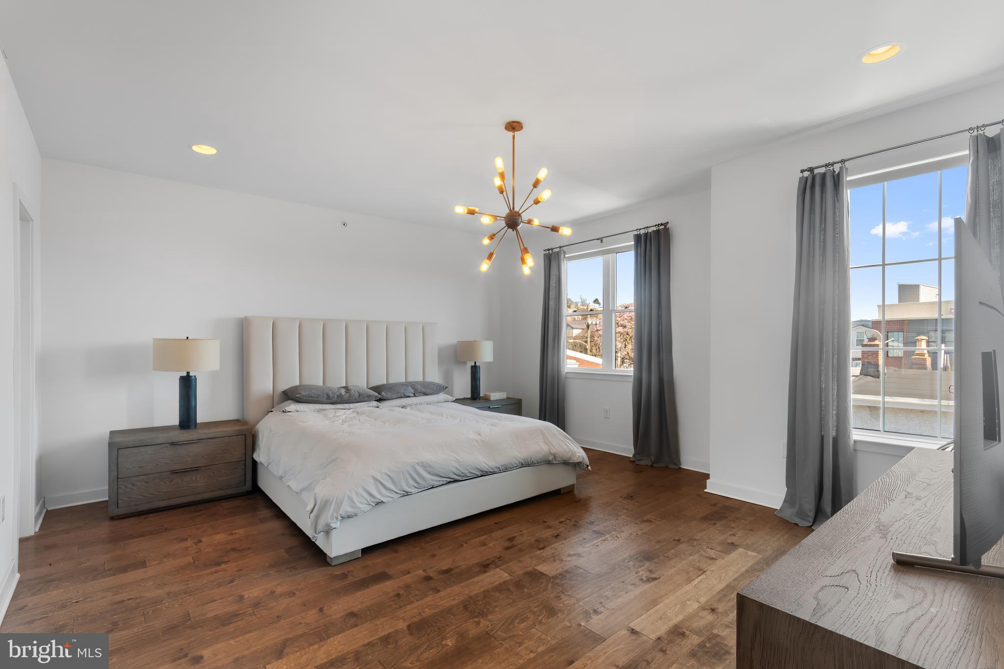 136 Burnside Street Philadelphia, PA 19127 - Photo 19 of 25 a spacious bedroom with a large bed chandelier and a window