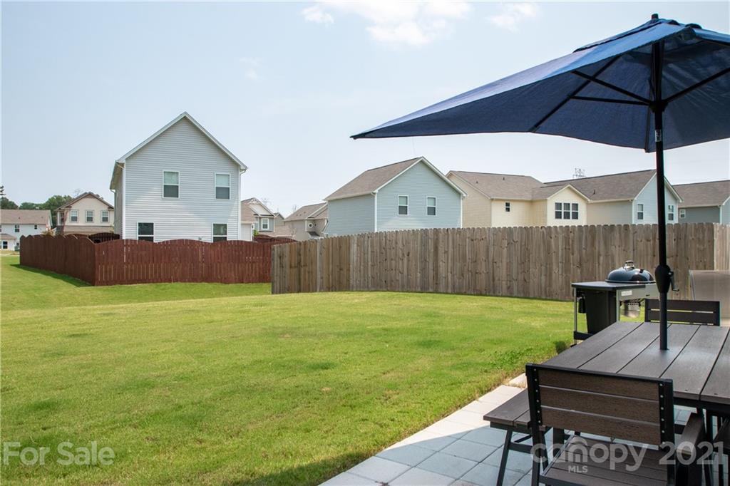 12511 Gotland Road, Unit 313 Midland, NC 28107 - Photo 29 of 31 a view of a backyard with table and chairs under an umbrella