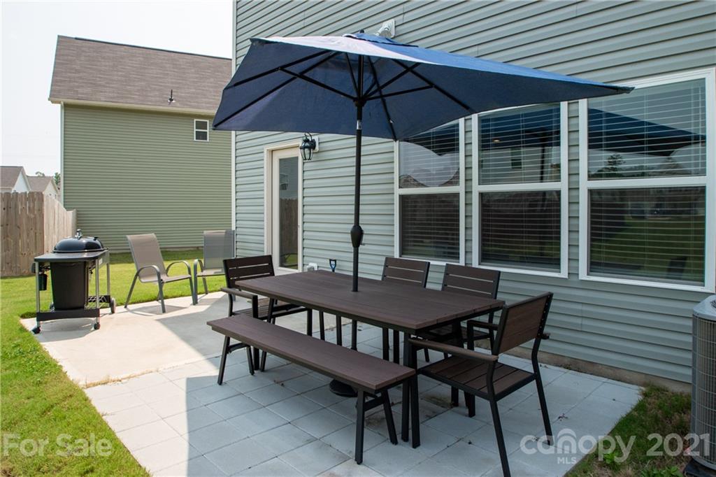 12511 Gotland Road, Unit 313 Midland, NC 28107 - Photo 31 of 31 a view of a patio with table and chairs under an umbrella