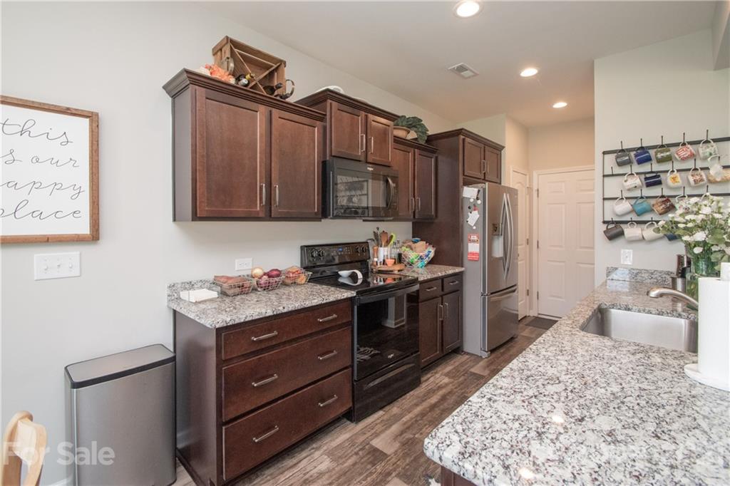 12511 Gotland Road, Unit 313 Midland, NC 28107 - Photo 10 of 31 a kitchen with stainless steel appliances granite countertop a stove refrigerator and cabinets