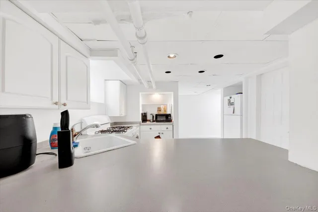 a view of a kitchen with a sink dishwasher stove and cabinets