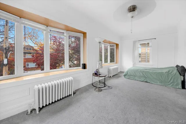 a bedroom with furniture and a large window