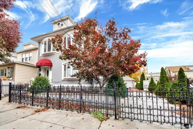 a front view of a house with a tree