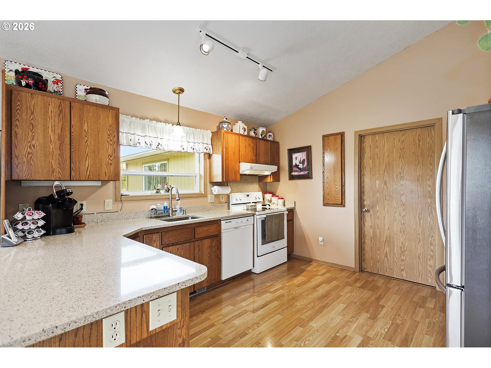 64 Seely Drive Goldendale, WA 98620 - Photo 9 of 46 a kitchen with a refrigerator a sink dishwasher with a dining table and chairs