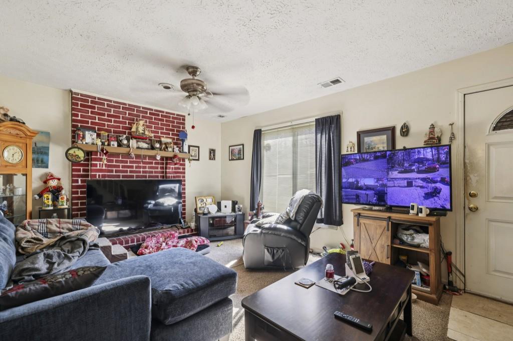 1331 North Hampton Road Alpharetta, GA 30009 - Photo 20 of 41 a living room with furniture a fireplace and a flat screen tv