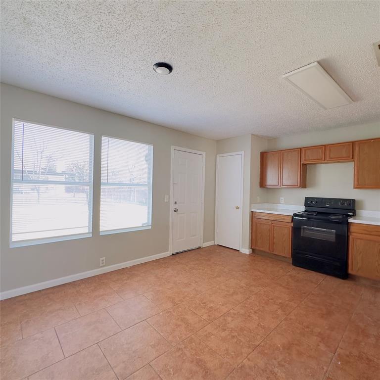 1414 Hardned Lane Dallas, TX 75217 - Photo 4 of 13 a kitchen with a stove a sink and a refrigerator