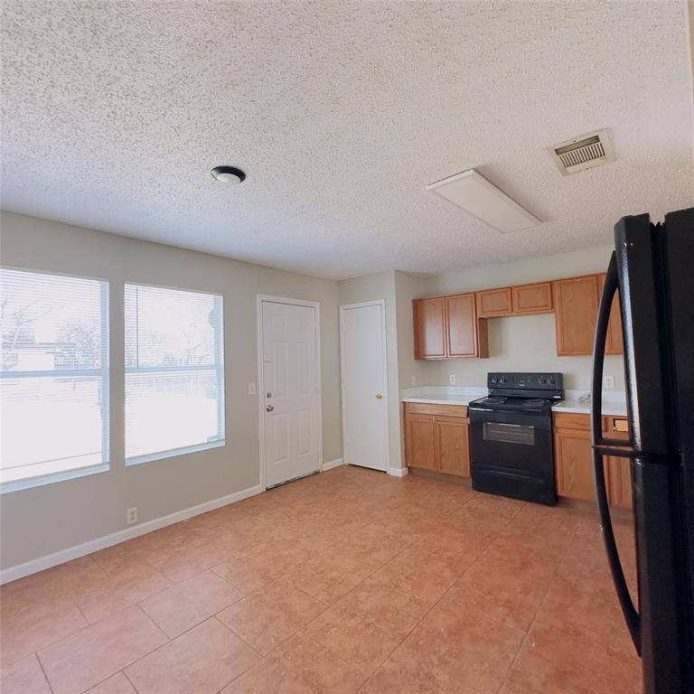 1414 Hardned Lane Dallas, TX 75217 - Photo 5 of 13 a kitchen with a refrigerator and a stove top oven