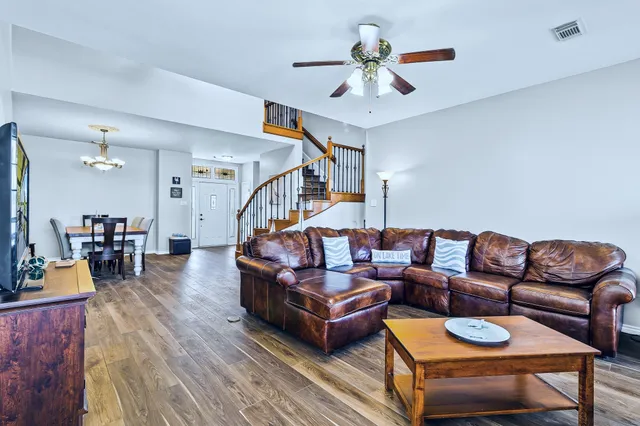 a living room with furniture a ceiling fan and a rug
