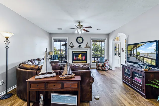 a living room with fireplace furniture a flat screen tv and a large window