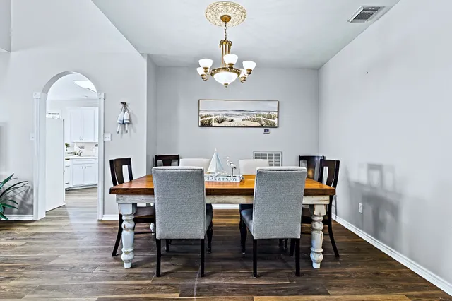 a view of a dining room with furniture a chandelier and wooden floor
