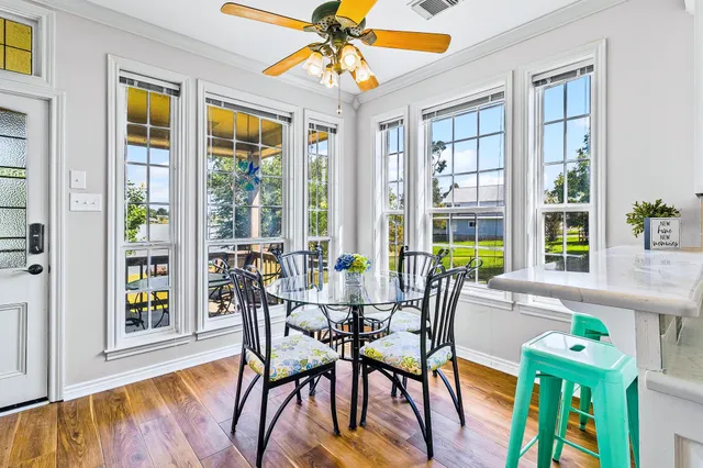 a dining room with furniture a chandelier and wooden floor